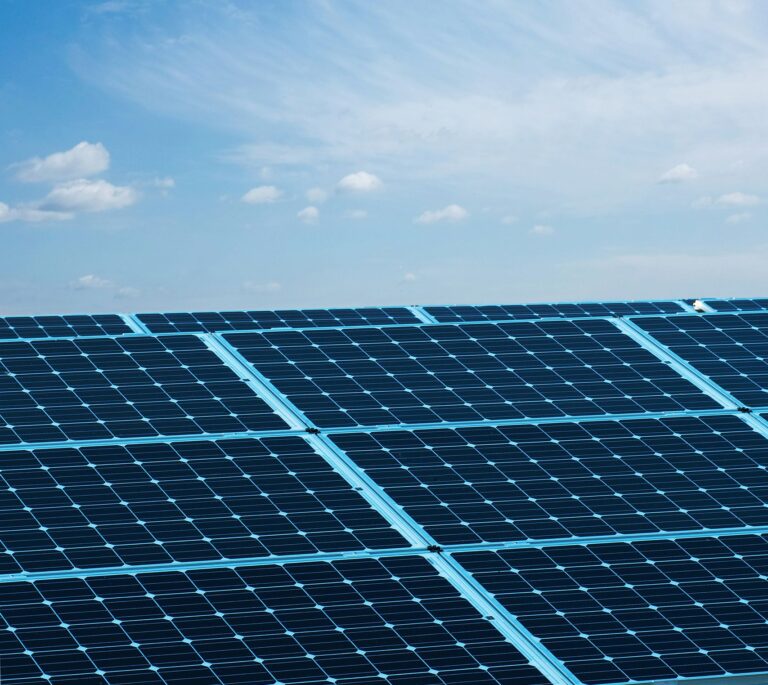 Solar panels under a clear blue sky, symbolizing renewable energy and sustainability.